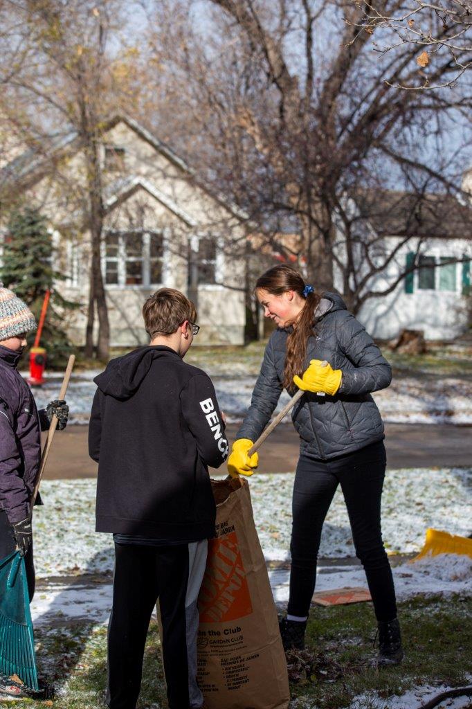 Students and teachers cleaning the leaves after the fall in the school area