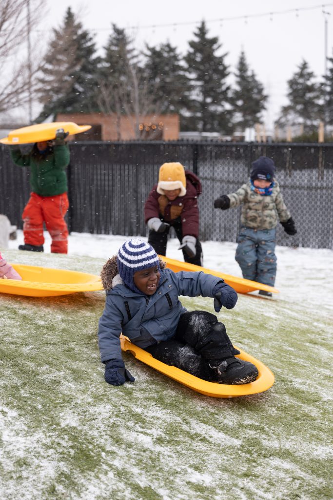 Student sledding on a hill